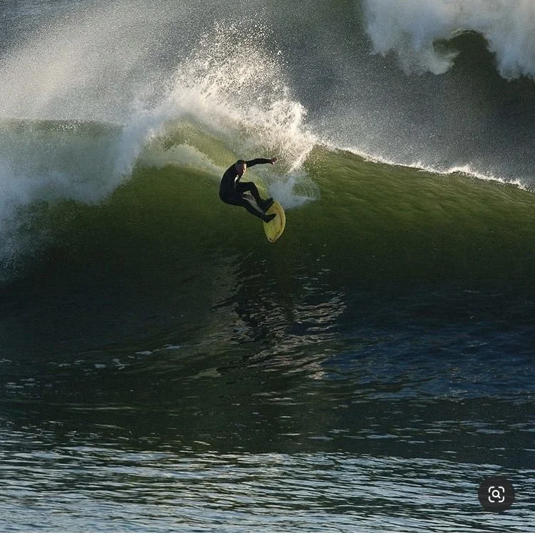 Surfer dropping into a heavy wave on a Vince Broglio surfboard