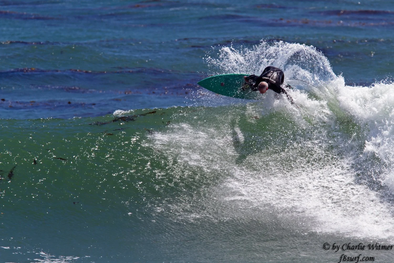 Surfer spraying water on a wave